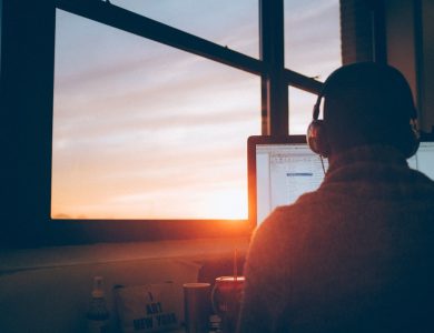 man sitting facing monitor