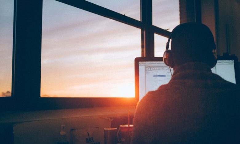 man sitting facing monitor