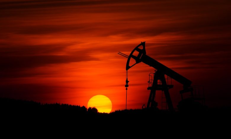 oil pump jack silhouette against red sunset