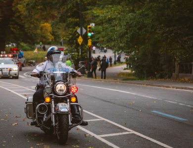 A police officer rides a motorcycle down the road.
