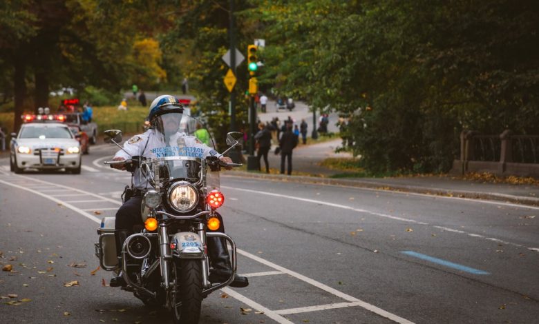A police officer rides a motorcycle down the road.