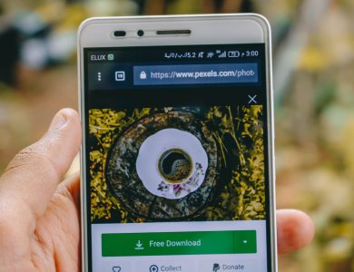 Close-up of a smartphone showing a coffee cup image on a screen outdoors.