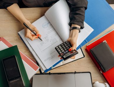 Accountant analyzing financial documents with a calculator on a desk, highlighting business tasks.