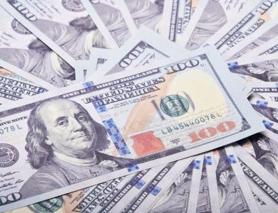 A stack of hundred dollar bills spread out, symbolizing wealth and financial success.