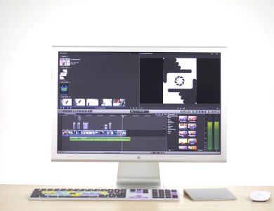 A sleek computer monitor displays video editing software in a modern workspace.