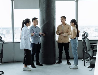 Diverse team discussing ideas in a modern office with city view, fostering collaboration.