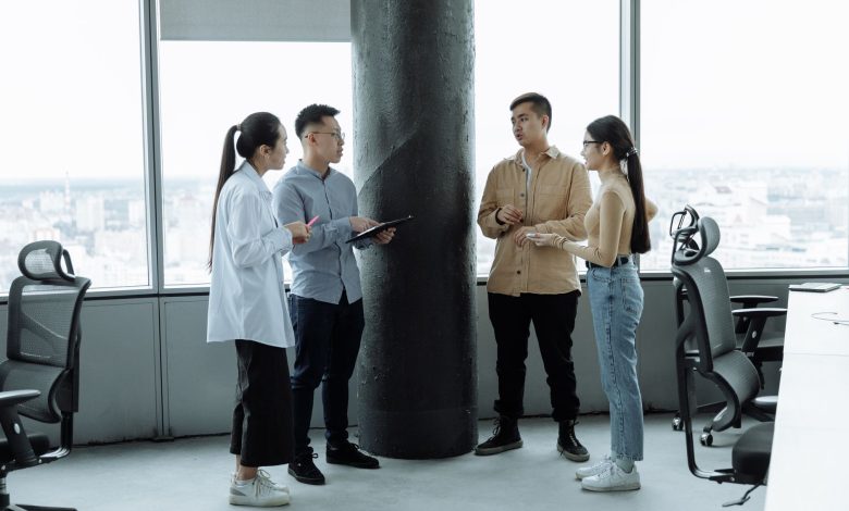 Diverse team discussing ideas in a modern office with city view, fostering collaboration.