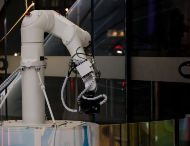 A white robotic arm operating indoors with a modern design and advanced technology.