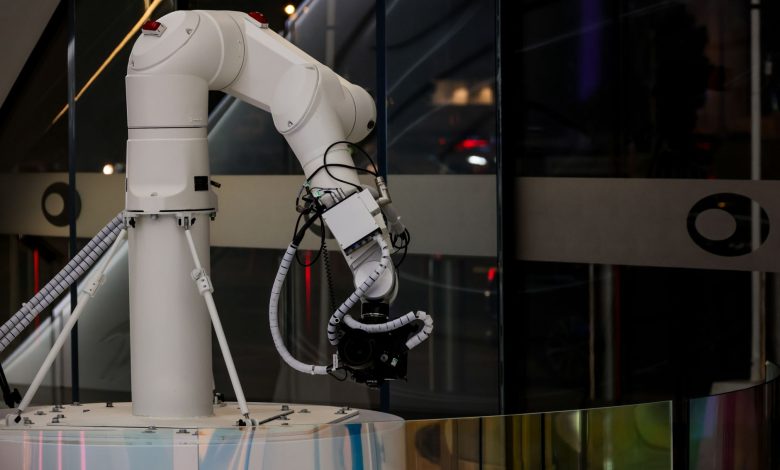 A white robotic arm operating indoors with a modern design and advanced technology.