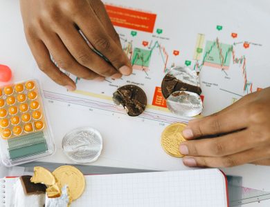 Analyzing financial charts with a calculator and chocolate coins.