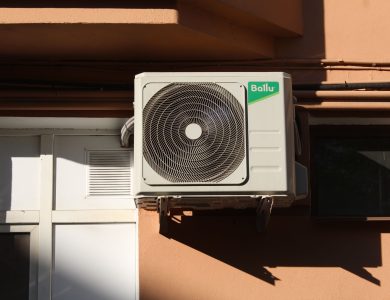 A Ballu air conditioner condenser unit mounted on a building exterior, showcasing modern HVAC technology.