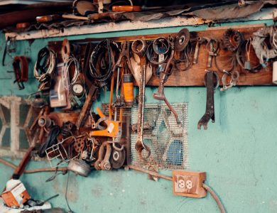 A collection of vintage tools hangs on a rustic workshop wall, creating a nostalgic and creative atmosphere.