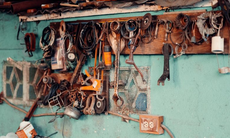 A collection of vintage tools hangs on a rustic workshop wall, creating a nostalgic and creative atmosphere.