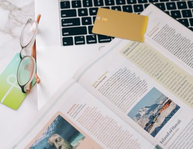 Close-up of a book, glasses, and laptop on a desk, ideal for education or productivity concepts.