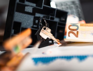 Keys with a house model, Euro bills, and charts suggesting real estate and financial themes.