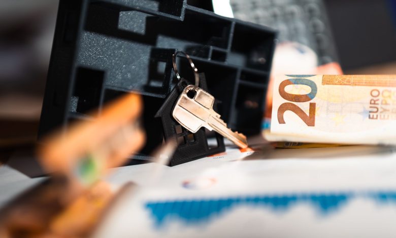 Keys with a house model, Euro bills, and charts suggesting real estate and financial themes.